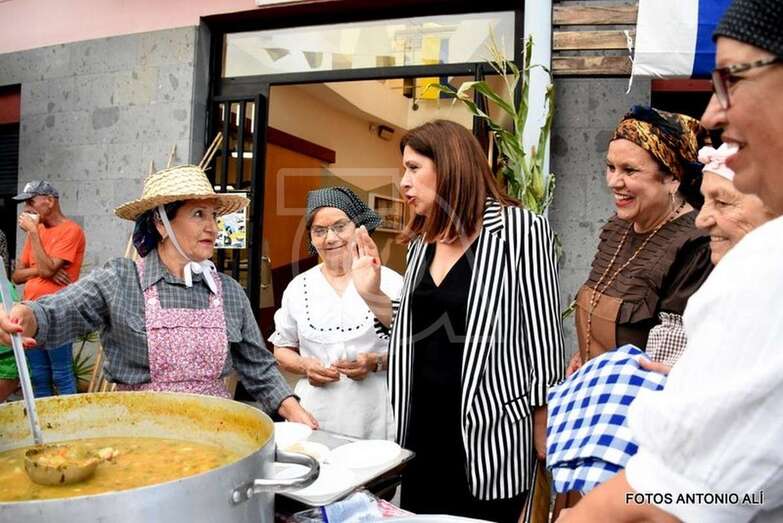 La alcaldesa Carmen Hernández observa la preparación del potaje canario en plena calle (Foto TA)